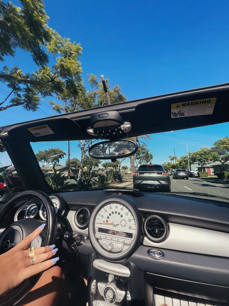 a woman driving a car down a street