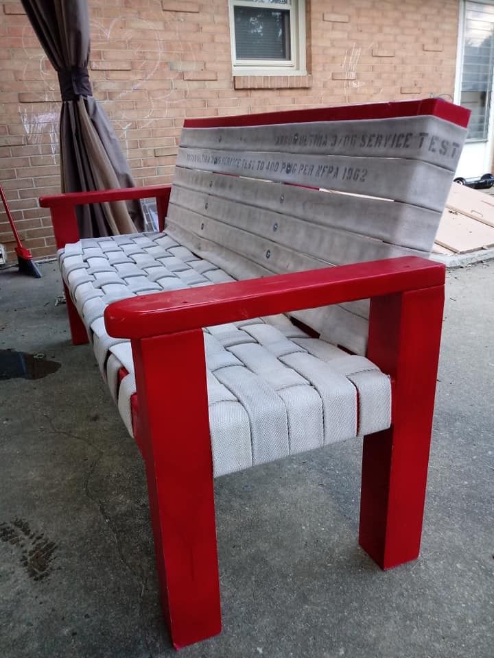 a bench made out of newspaper sitting in front of a brick building