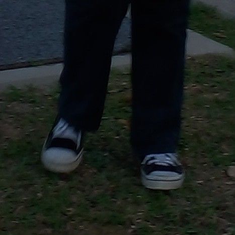 a person standing in the grass with their shoes on