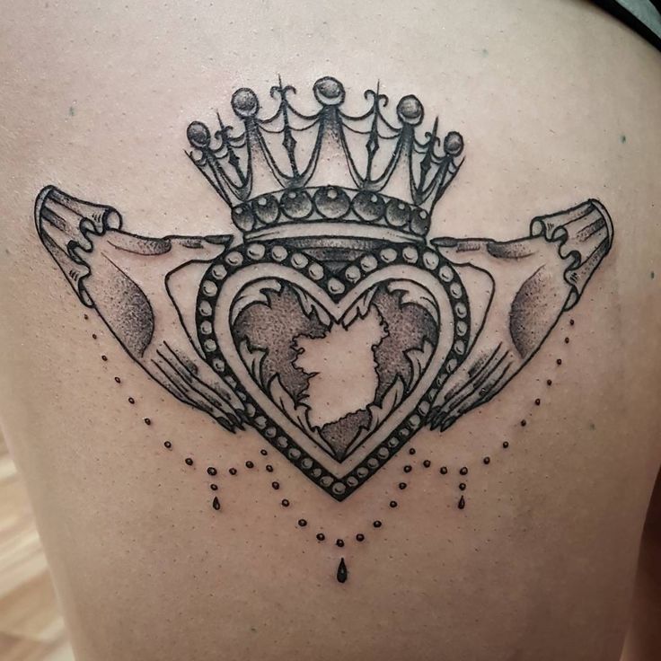 the back of a woman's stomach with a crown and heart tattoo on it