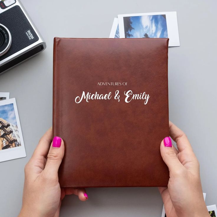 two hands holding a brown leather album with the words michael and enliy on it