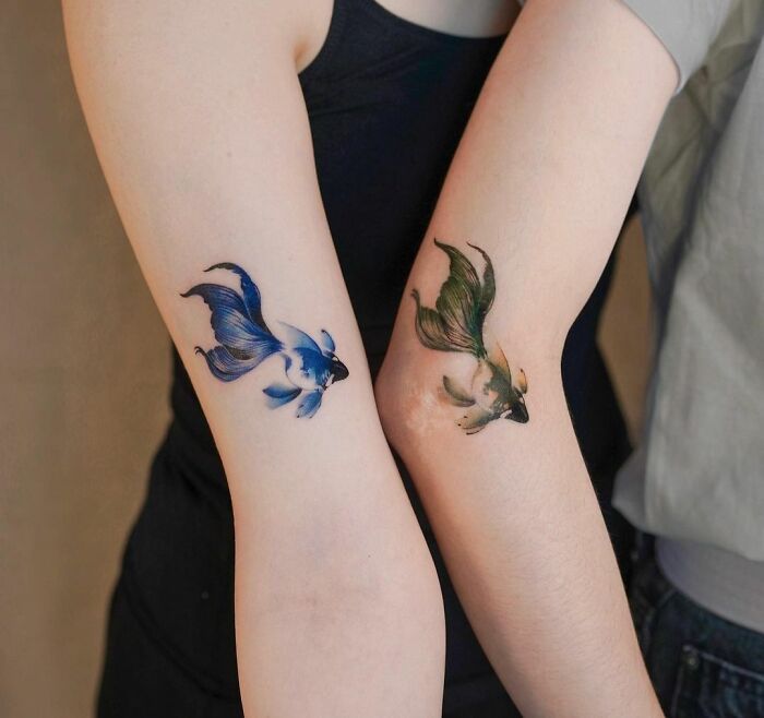 two people with matching tattoos on their arms