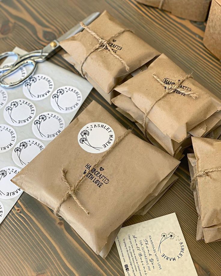 some brown paper bags are tied up with twine and scissors on a wooden table