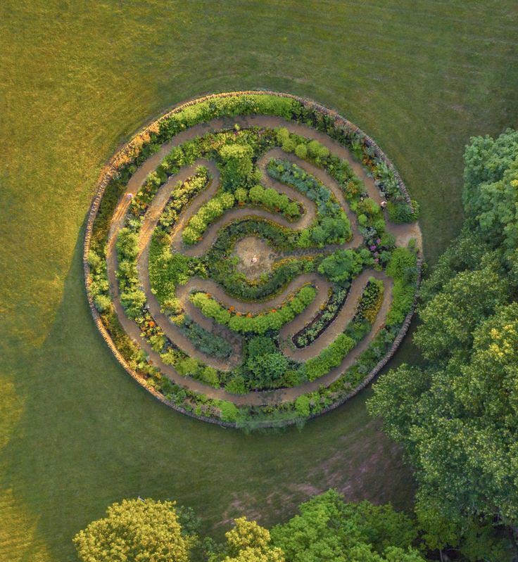 an aerial view of a circular garden in the middle of a field with trees around it