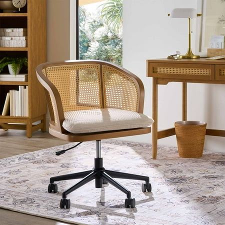 an office chair sitting on top of a rug in front of a desk with a lamp