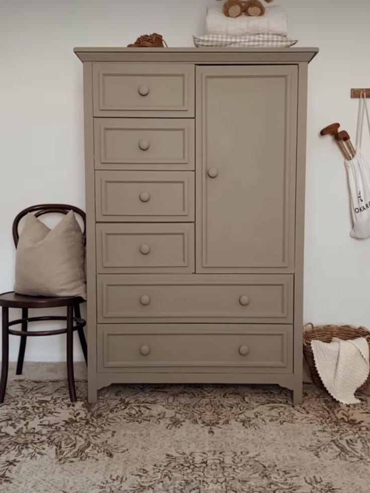 a baby's room with an armoire and dresser