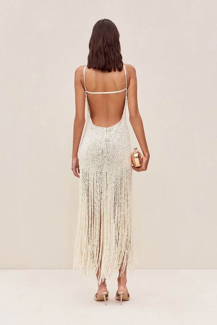 the back of a woman wearing a white fringe dress