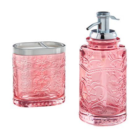 a pink glass soap dispenser and toothbrush holder