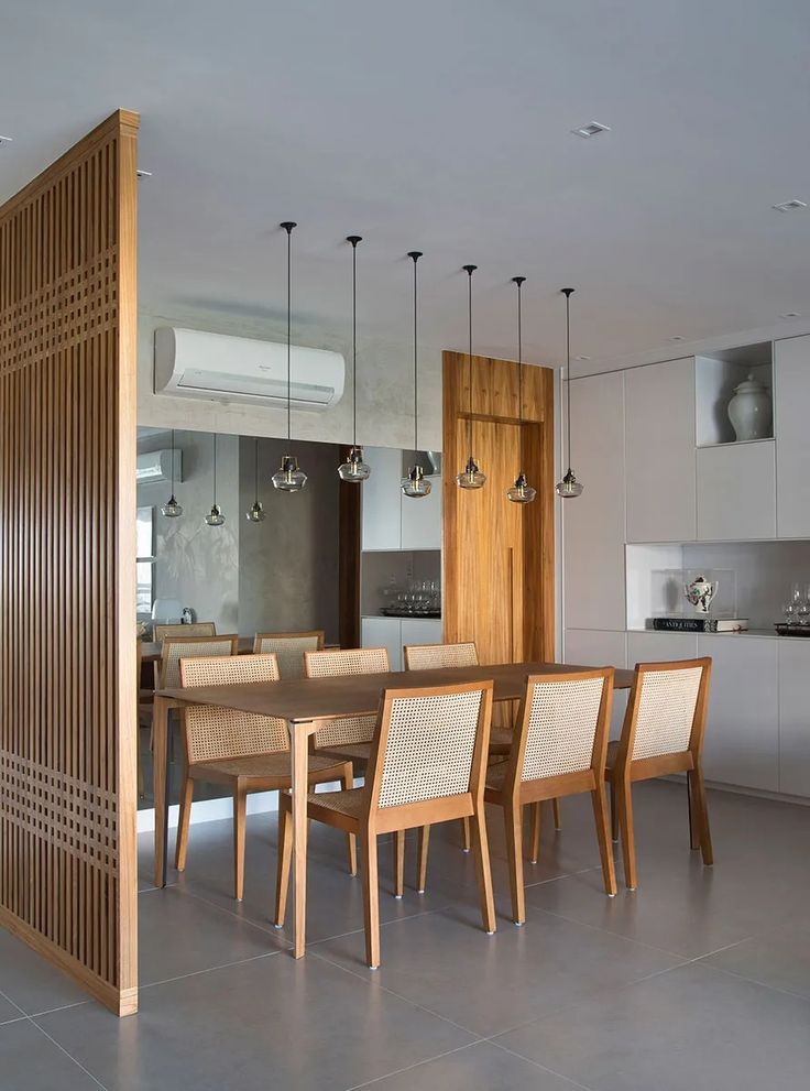 a dining room table and chairs in front of an open kitchen