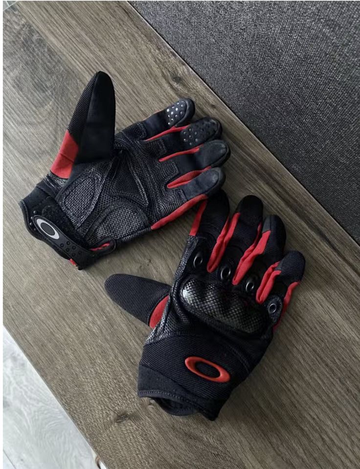 a pair of black and red gloves sitting on top of a wooden floor