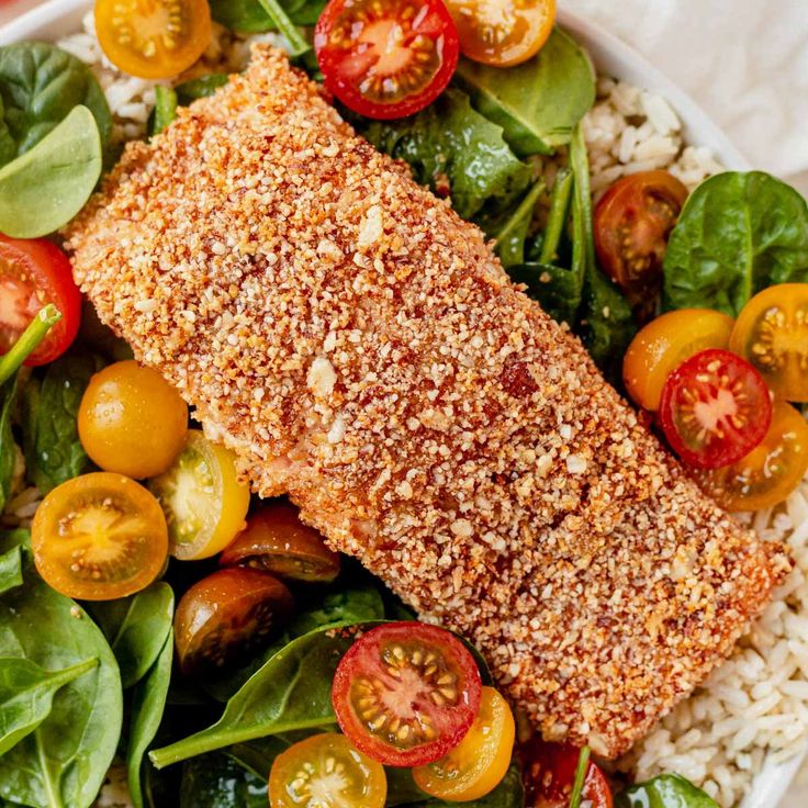 a white bowl filled with salad and fish on top of rice covered in seasoning