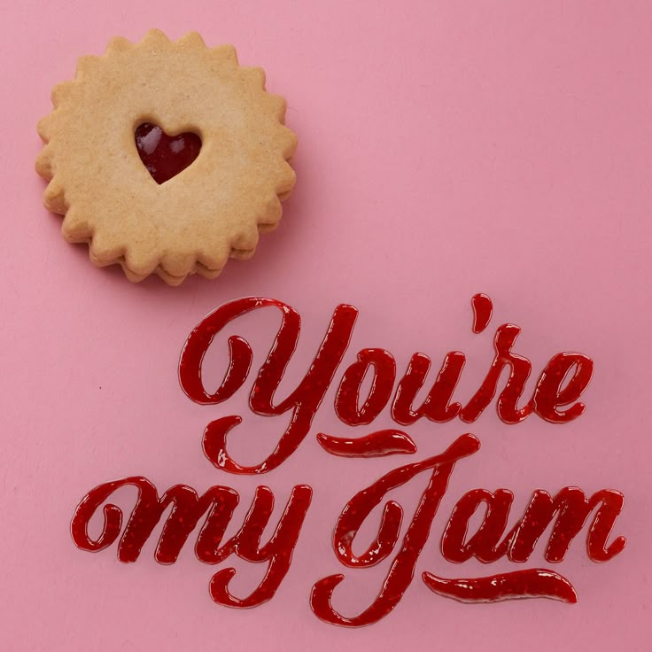 a cookie with the words you're my jam on it next to a heart shaped cookie