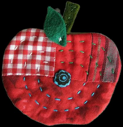 a red apple with a green leaf on it's side and a checkered fabric patch in the middle