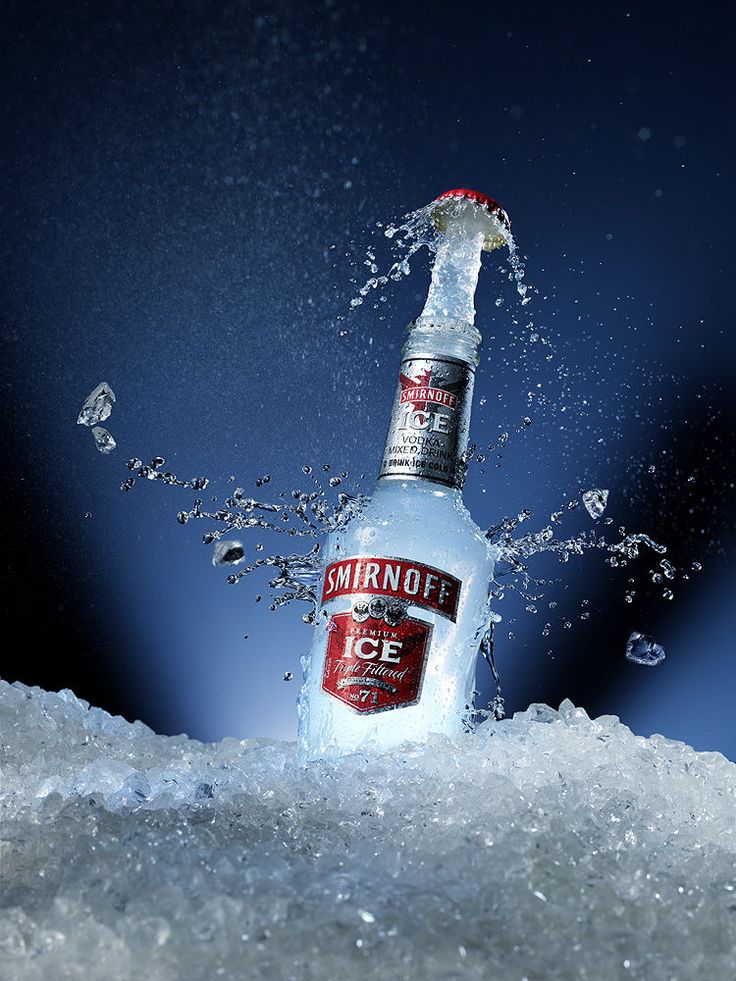 a bottle of smirnoff is splashing out of the ice