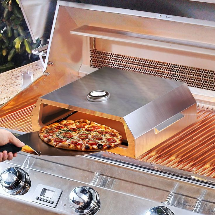 a pizza is being cooked on an outdoor grill