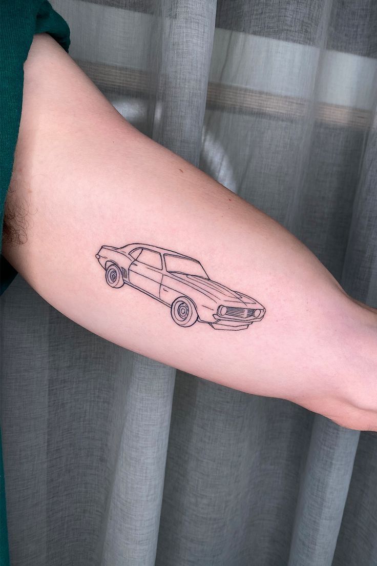 a man's arm with a car tattoo on it