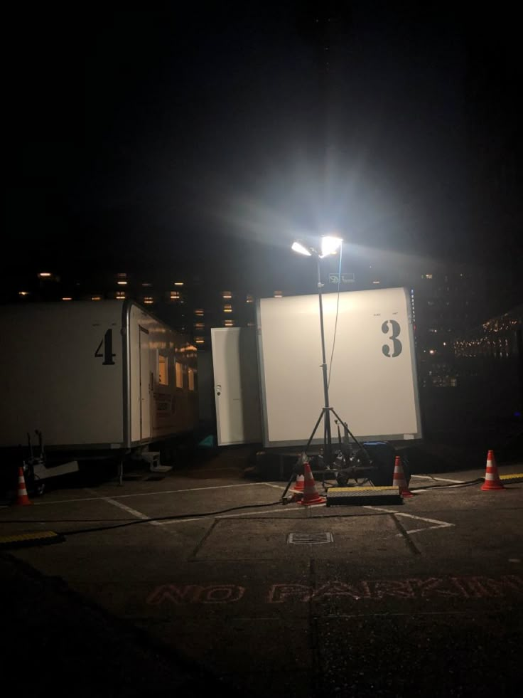 a photo studio set up in the middle of a parking lot at night with lights on