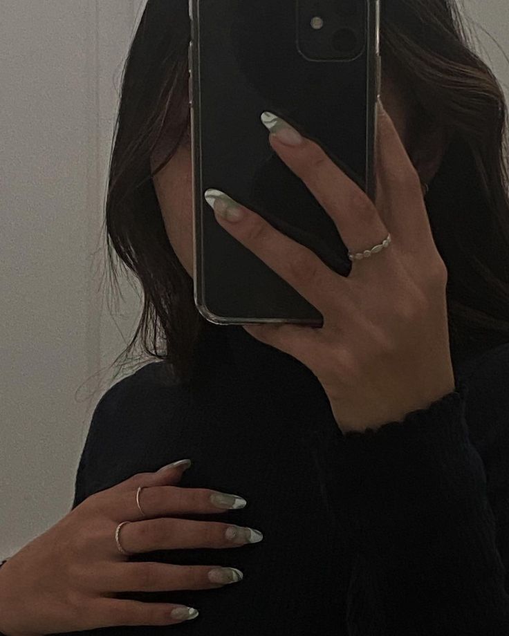 a woman taking a selfie in the mirror with her cell phone up to her face