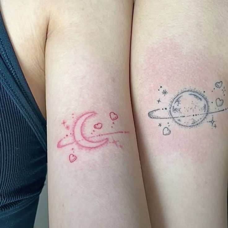 two women with tattoos on their arms, one has a saturn tattoo and the other has a star