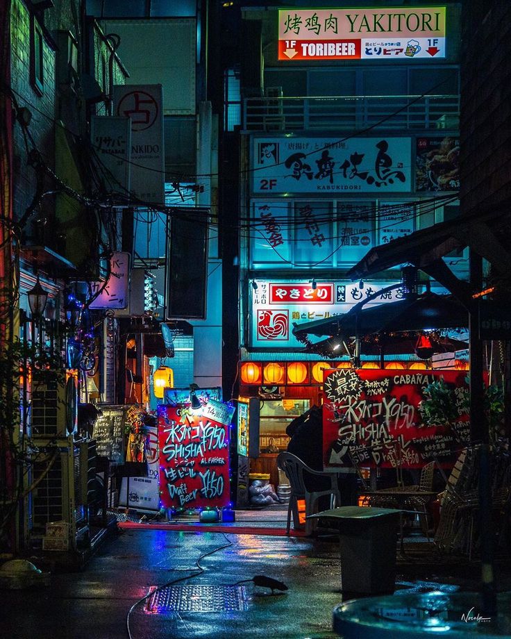 an alley at night with neon lights and graffiti on the walls