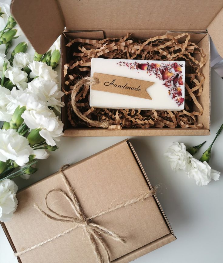 an open box containing a soap and some flowers