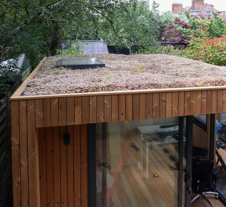 a wooden building with a green roof