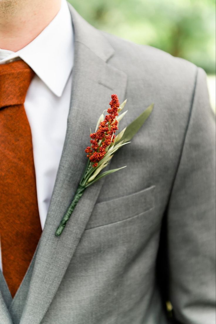 a man in a suit and tie with a boutonniere on his lapel