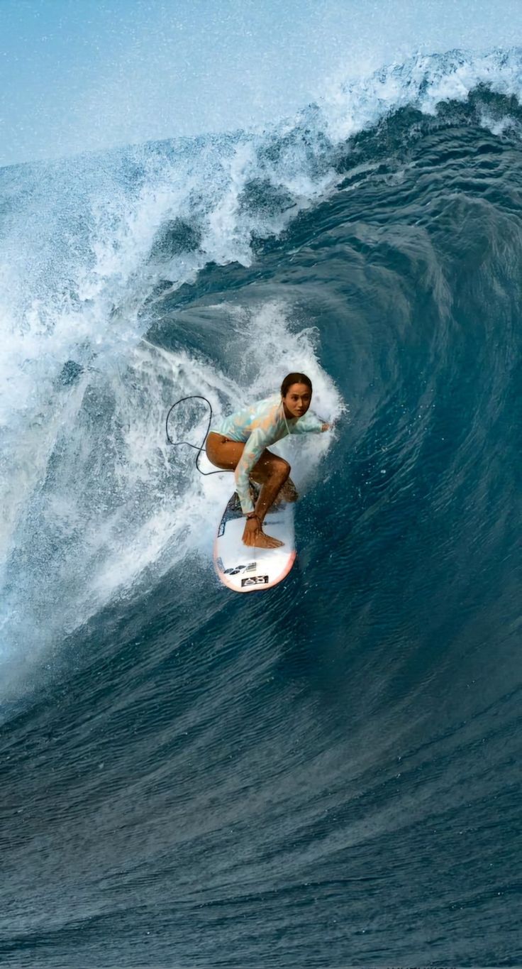 a man riding a wave on top of a surfboard in the middle of an ocean