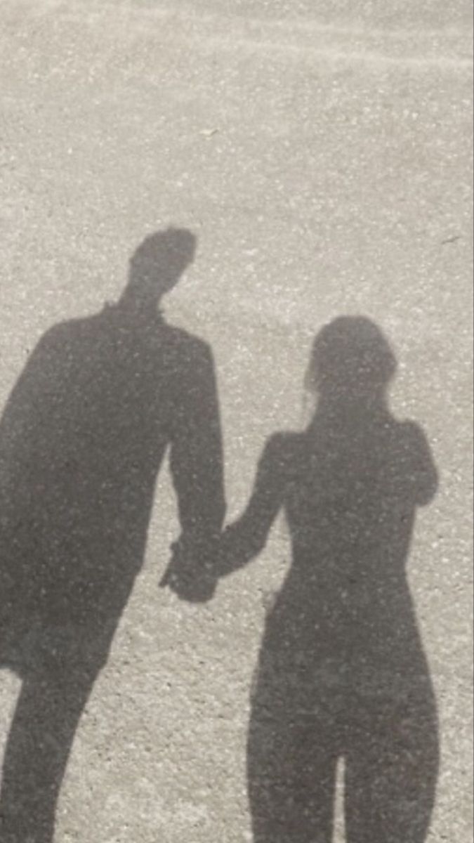 the shadow of two people holding hands