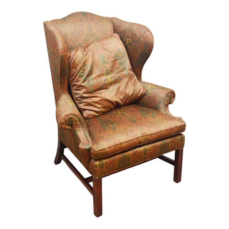 an upholstered wingback chair with gold and orange fabric on the back, against a white background