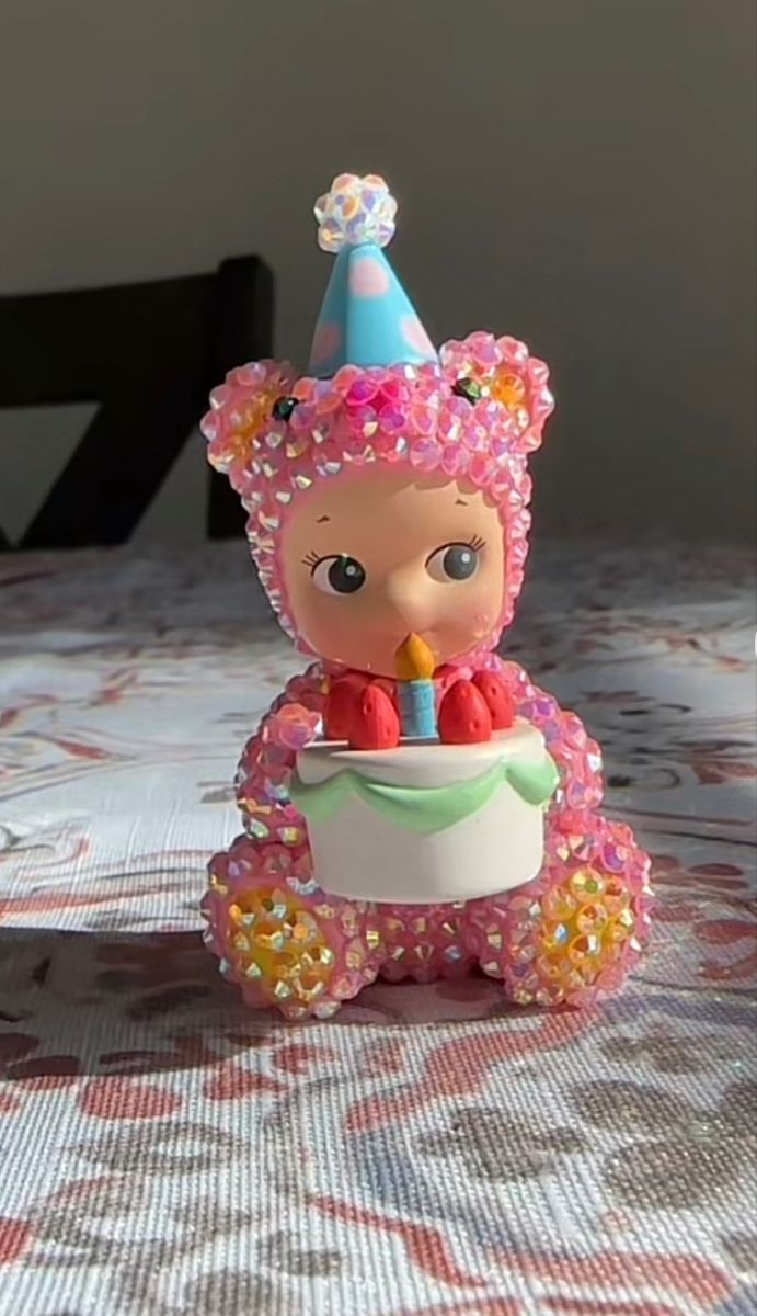 a small toy bear with a birthday hat on