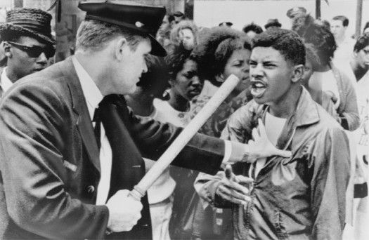 an old black and white photo of two men shaking hands in front of a crowd