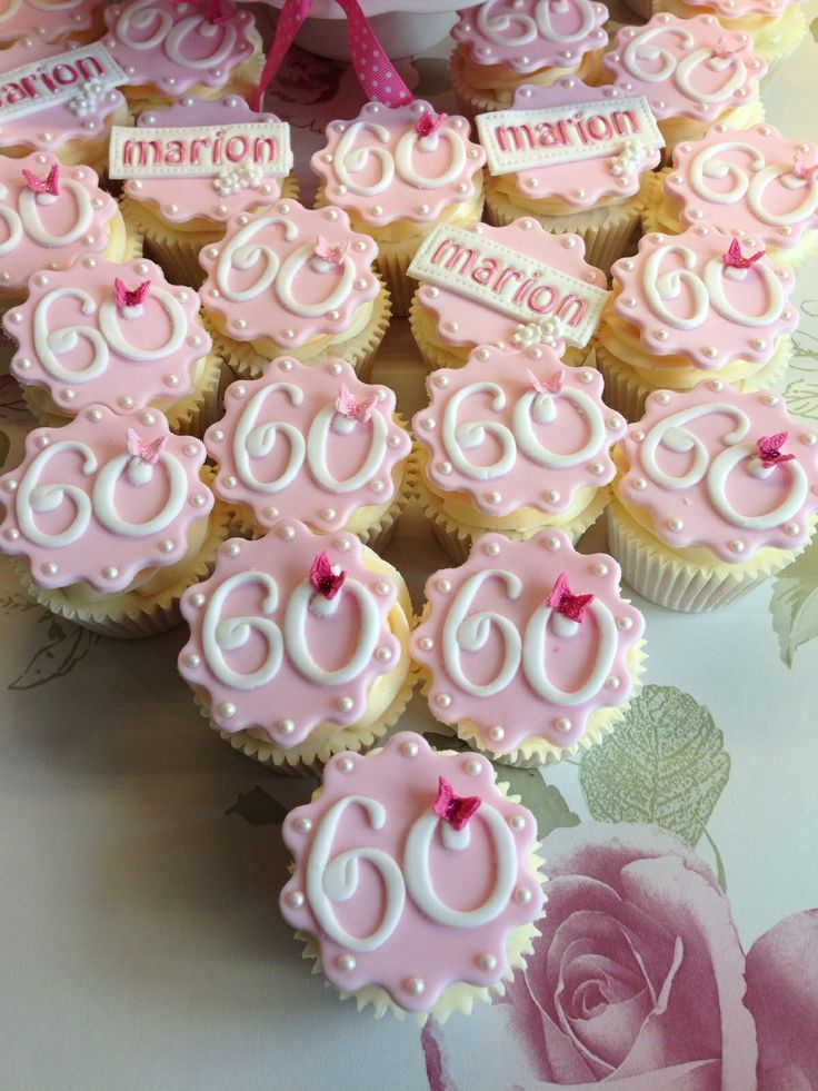 cupcakes with pink frosting are arranged on a table