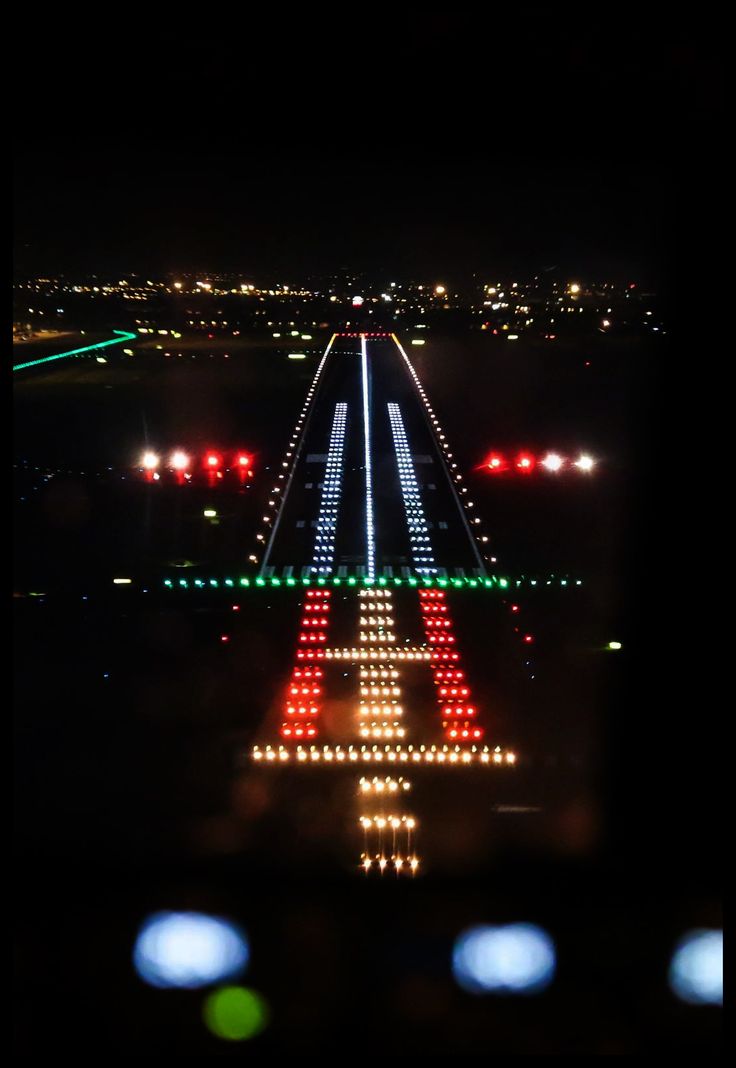 an airport runway lit up in red, white and green