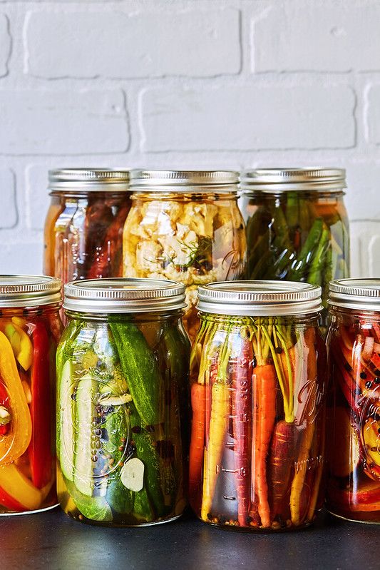 several jars filled with different types of vegetables