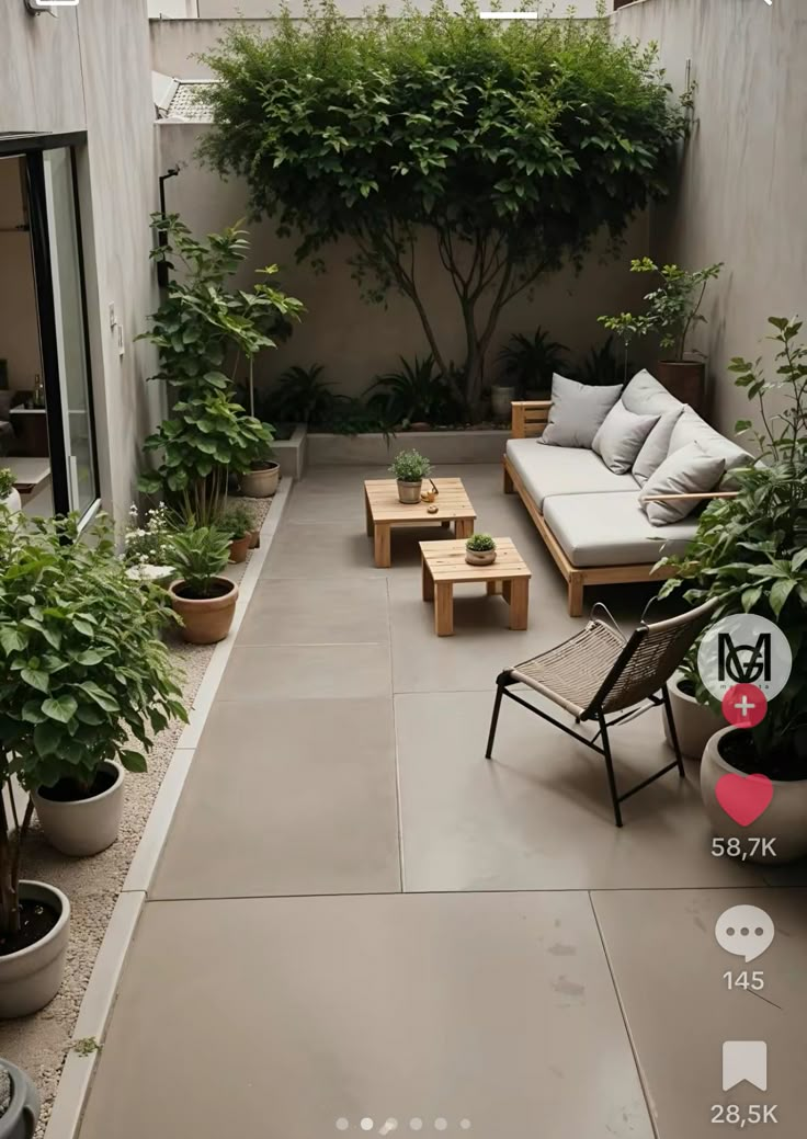 an outdoor living area with couches, tables and potted plants on the floor