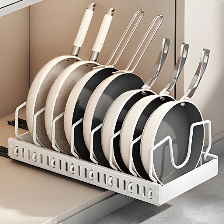 the dish rack is organized with pots and pans in black and white dishes,