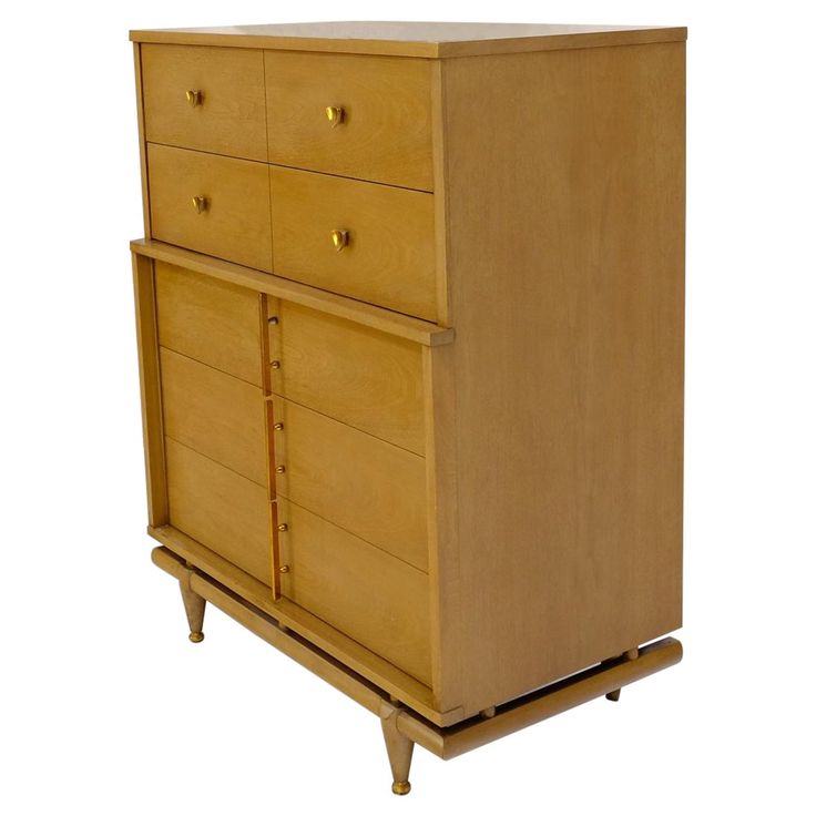 a wooden dresser with four drawers and three legs