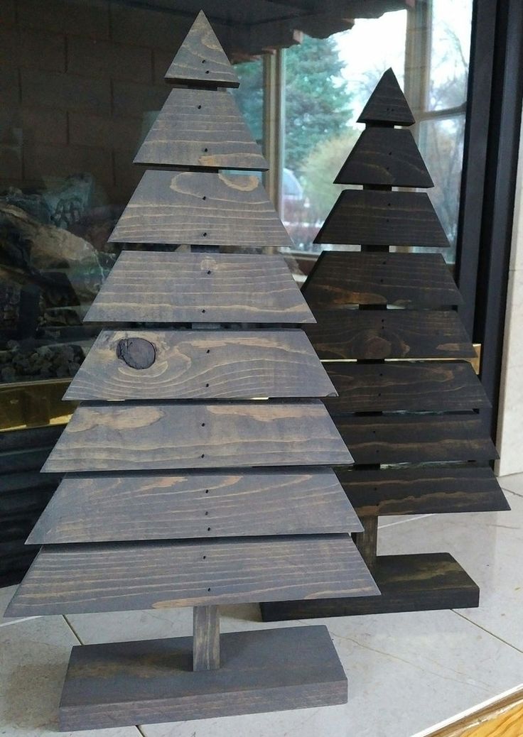 a wooden christmas tree sitting on top of a counter next to a window sill