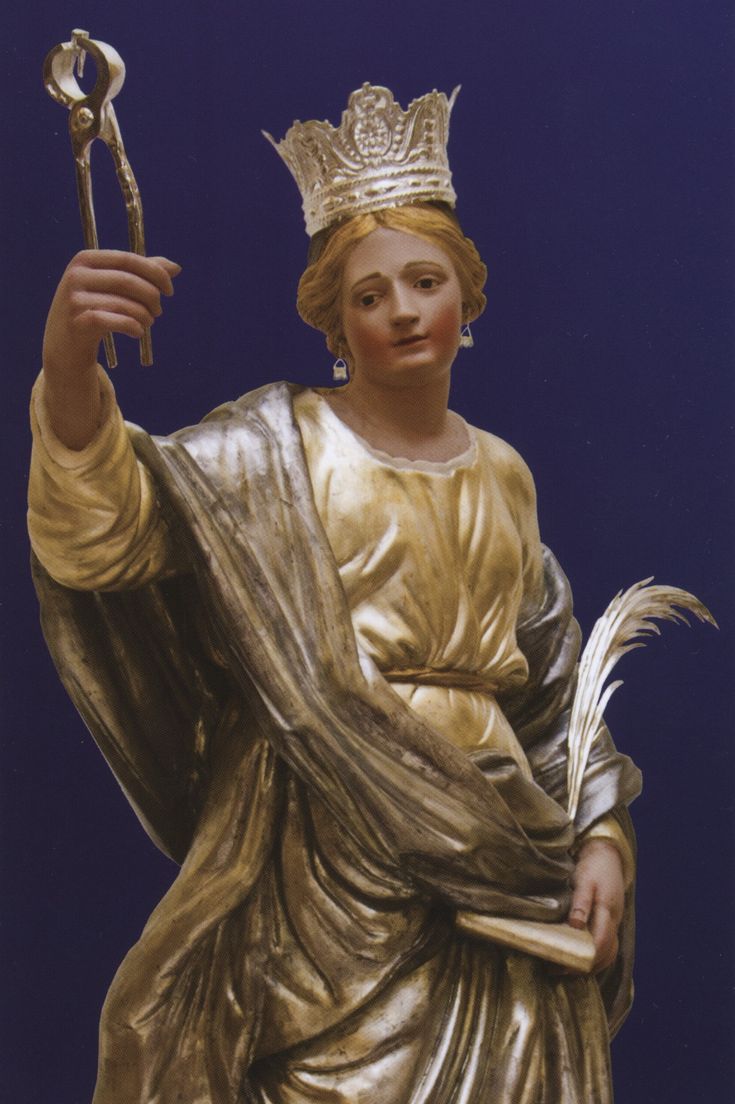 a statue of a woman holding a wrench and wearing a gold dress with a crown on her head