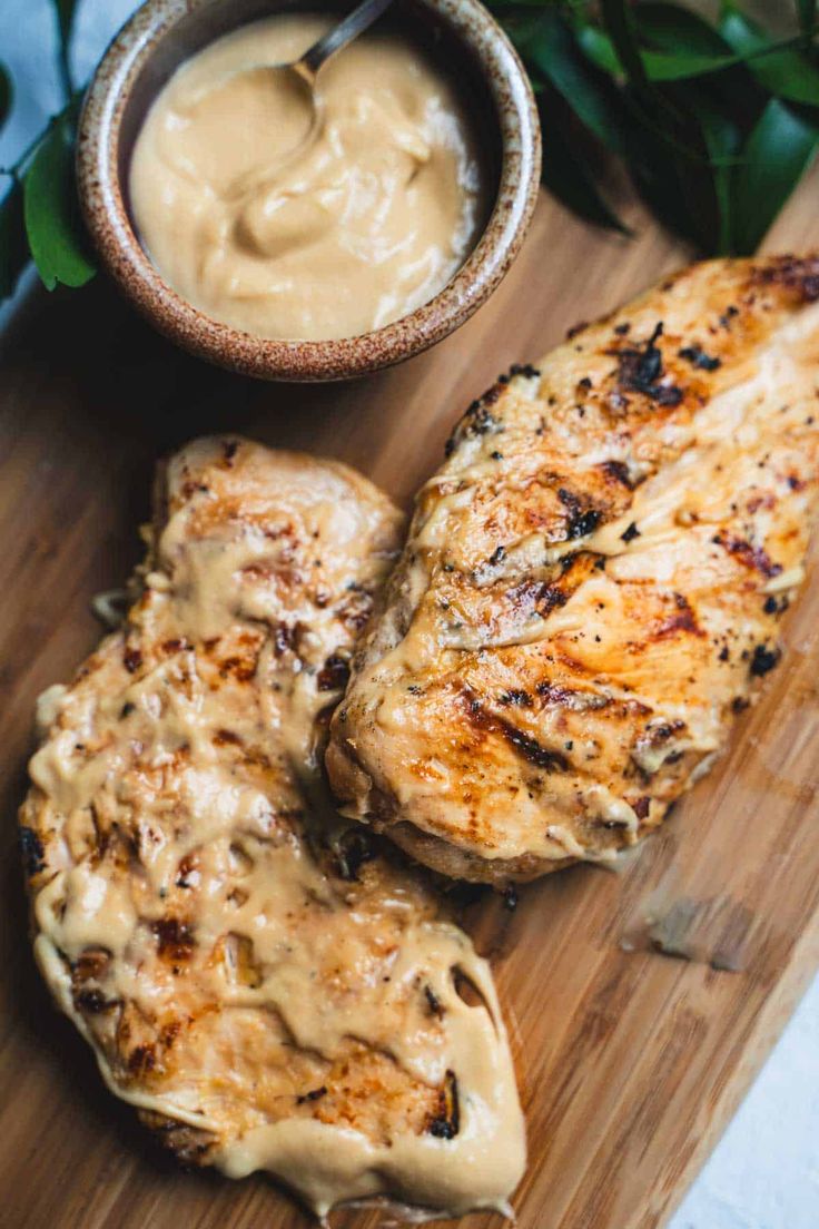 grilled pork chops on a cutting board with sauce