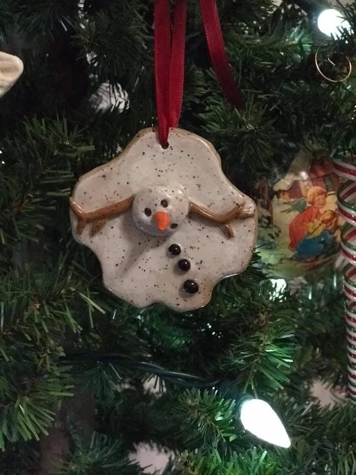 a snowman ornament hanging from a christmas tree