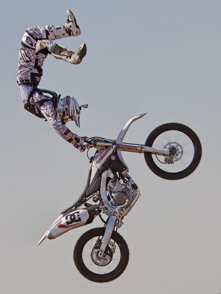 a man flying through the air while riding a motorcycle