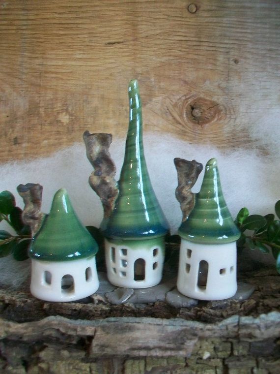 three green and white ceramic houses sitting on top of a shelf