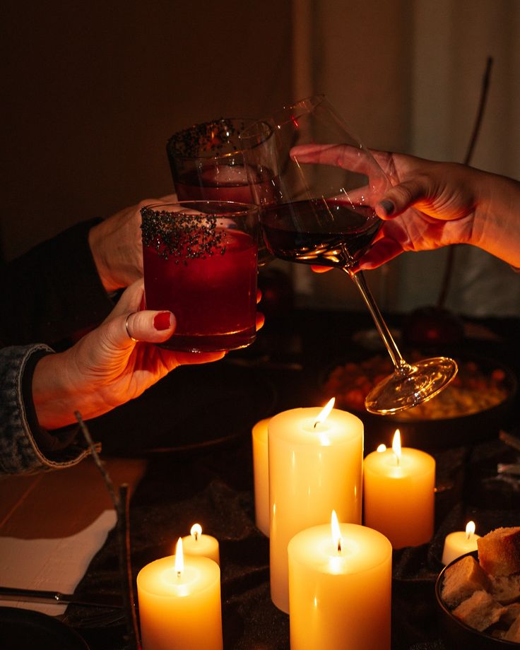 people toasting with wine and candles on a table