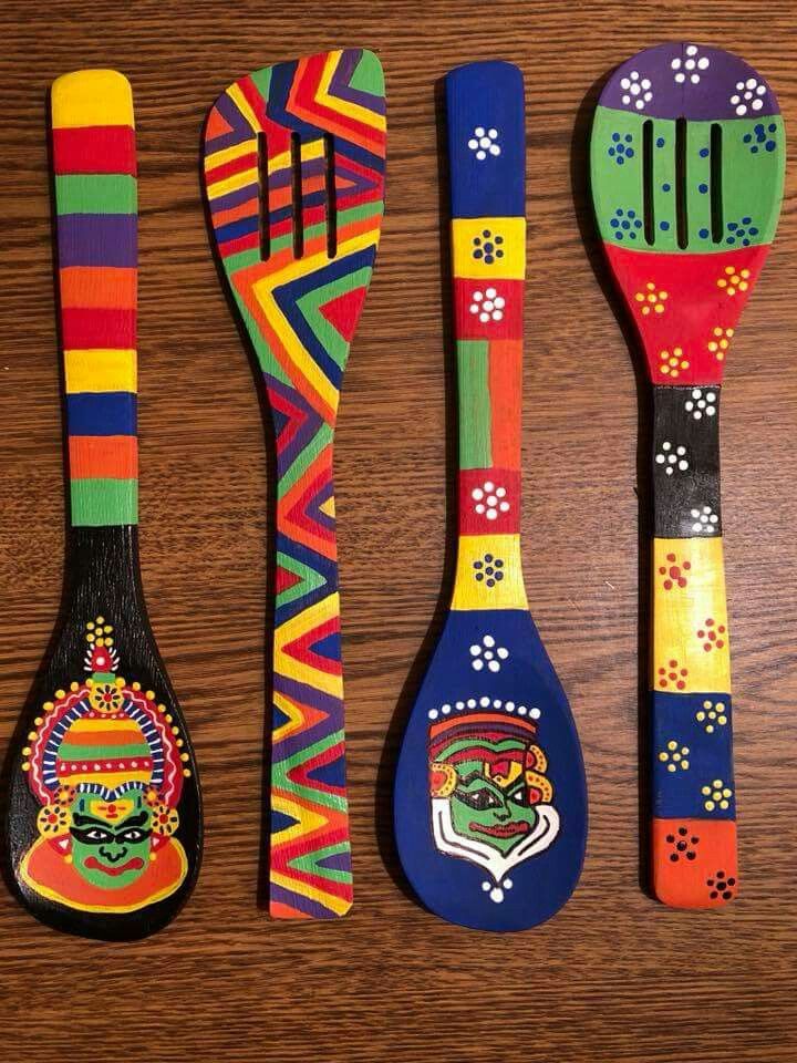 four wooden spoons with painted designs on them