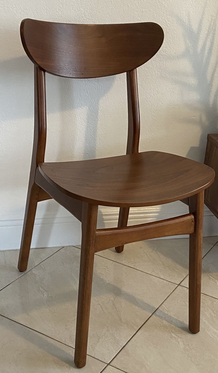 a wooden chair sitting on top of a tiled floor