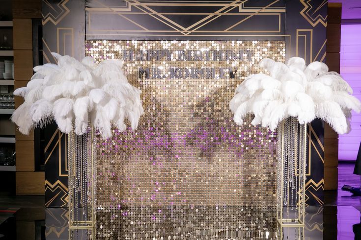 an art deco display with white feathers and sequins