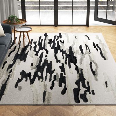 a modern rug with black and white paint on it in front of a large window