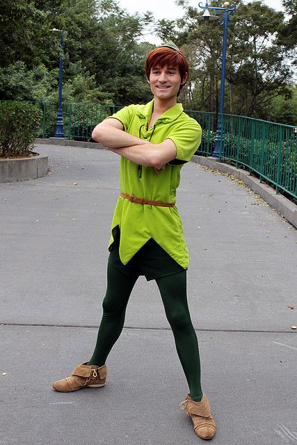 a man in green shirt and leggings posing with his arms crossed on the ground